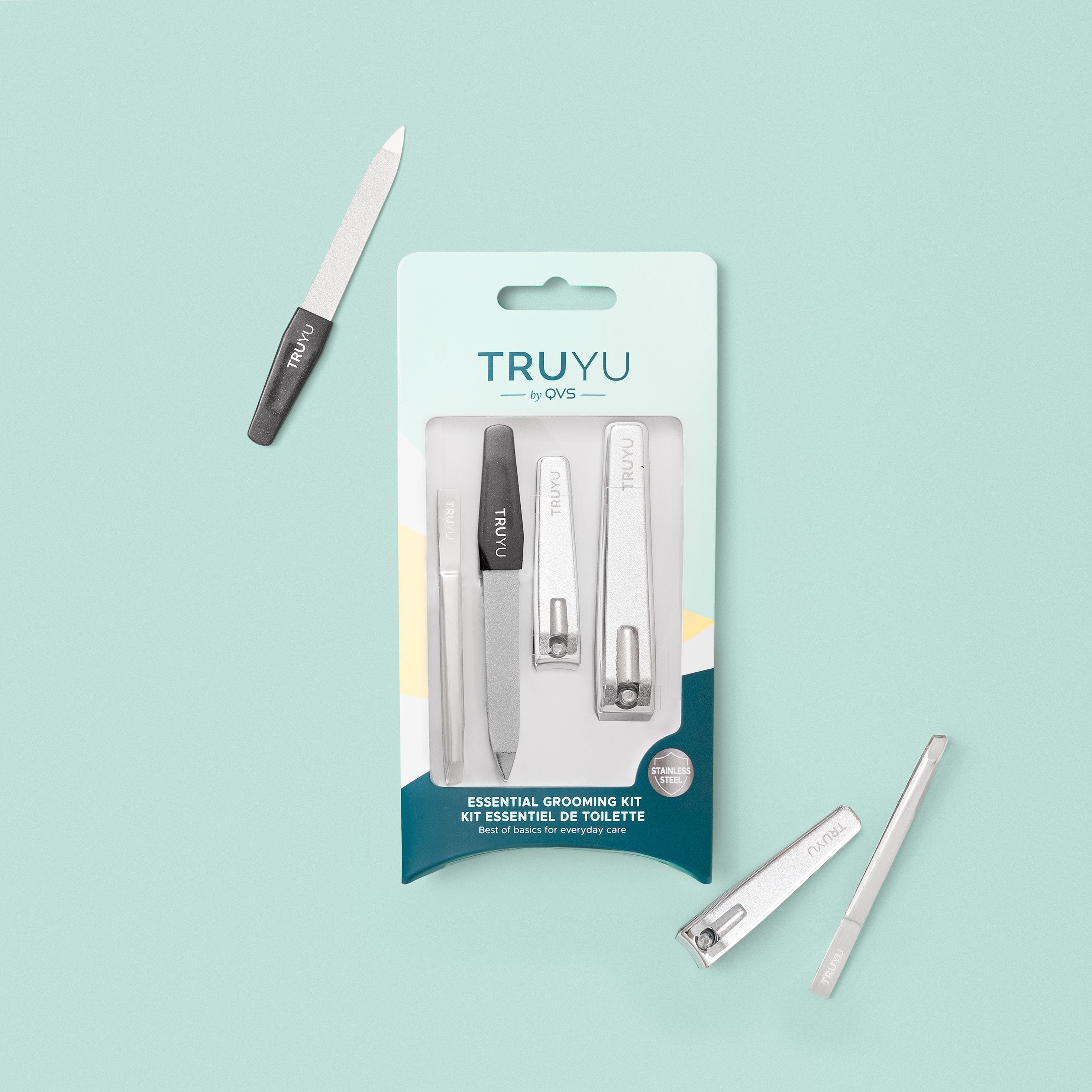TRUYU Essential Grooming Kit. Tweezer, Nail File Nail and Toenail Clipper in packaging and some products of of packaging. on a blue background