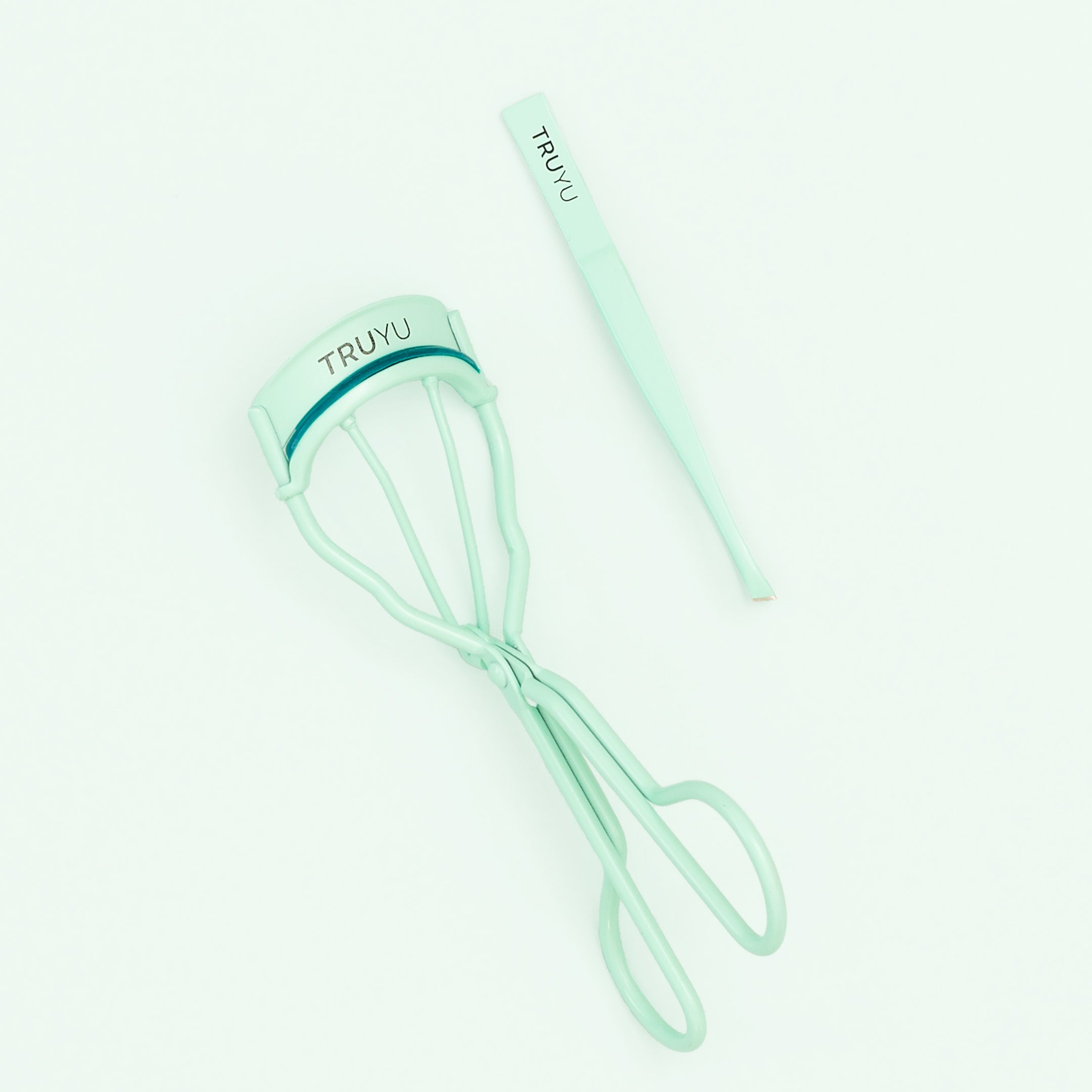 TRUYU Mint Blue Brow and Lash Set. Eyelash Curler and Tweezer. Out of Packagaing on a blue background