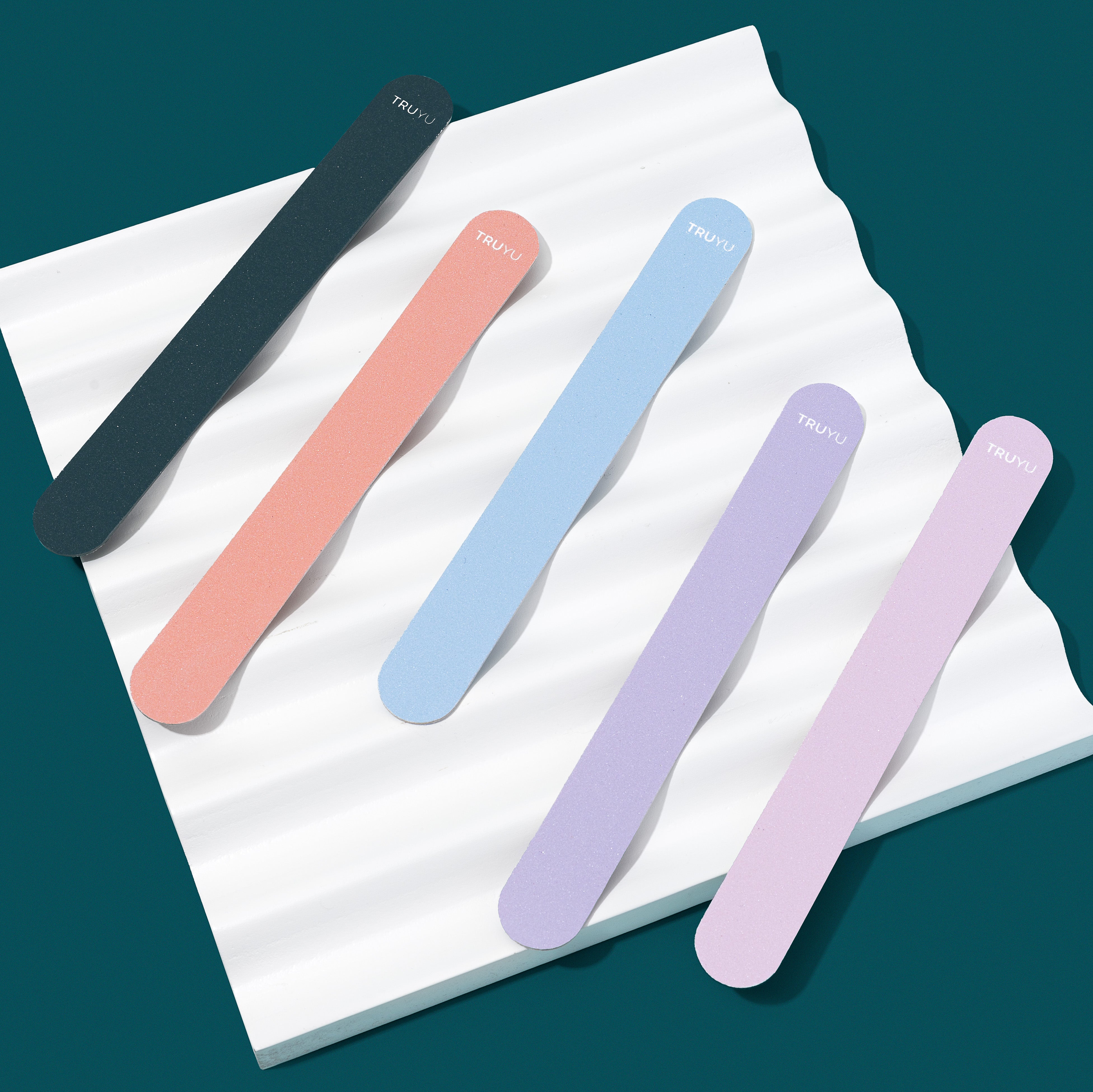 TRUYU Emery Files 5 pack multi colours. on white wave board on top of dark blue background