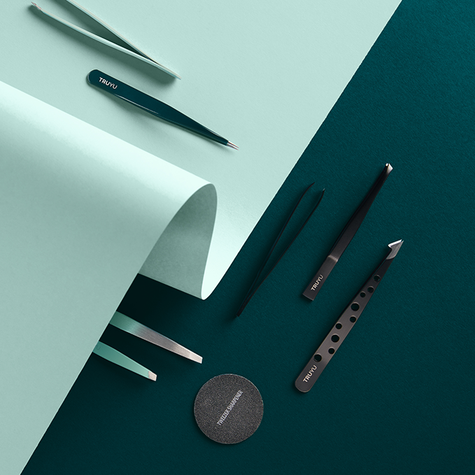 Set of TRUYU Tools on light blue  and dark green background. Includes, Slant Tip Tweezers, Point Tip Tweezers, Combo Tip Tweezers & Circular Sharpener