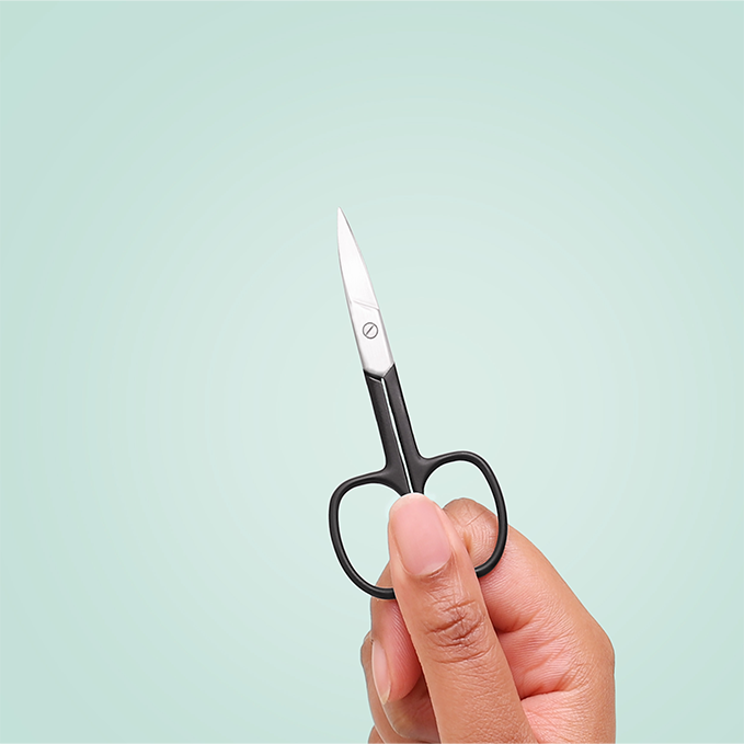 Hand holding TRUYU Black Curved Nail Scissors against a light blue background.