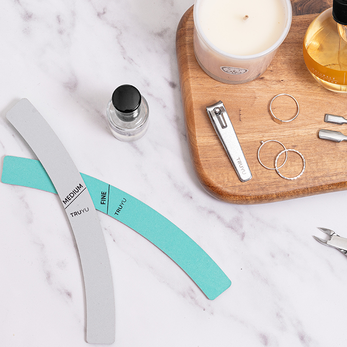 TRUYU Manicure Tools including Curved Nail Shapers, Cuticle Nipper, and Curved Nail Clippers on a marble surface with a wooden tray.