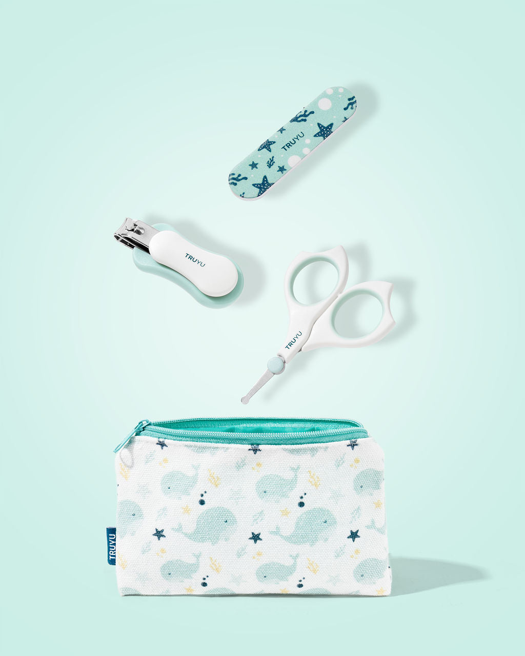Set of baby care items including a pouch with whale pattern, nail clipper, nail file and scissors on a light blue background.