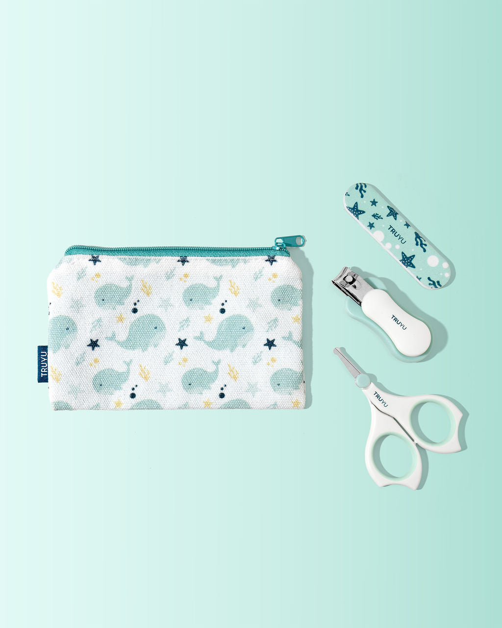 Baby nail set with scissors, nail file, nail clipper and pouch with whale pattern on a light blue background