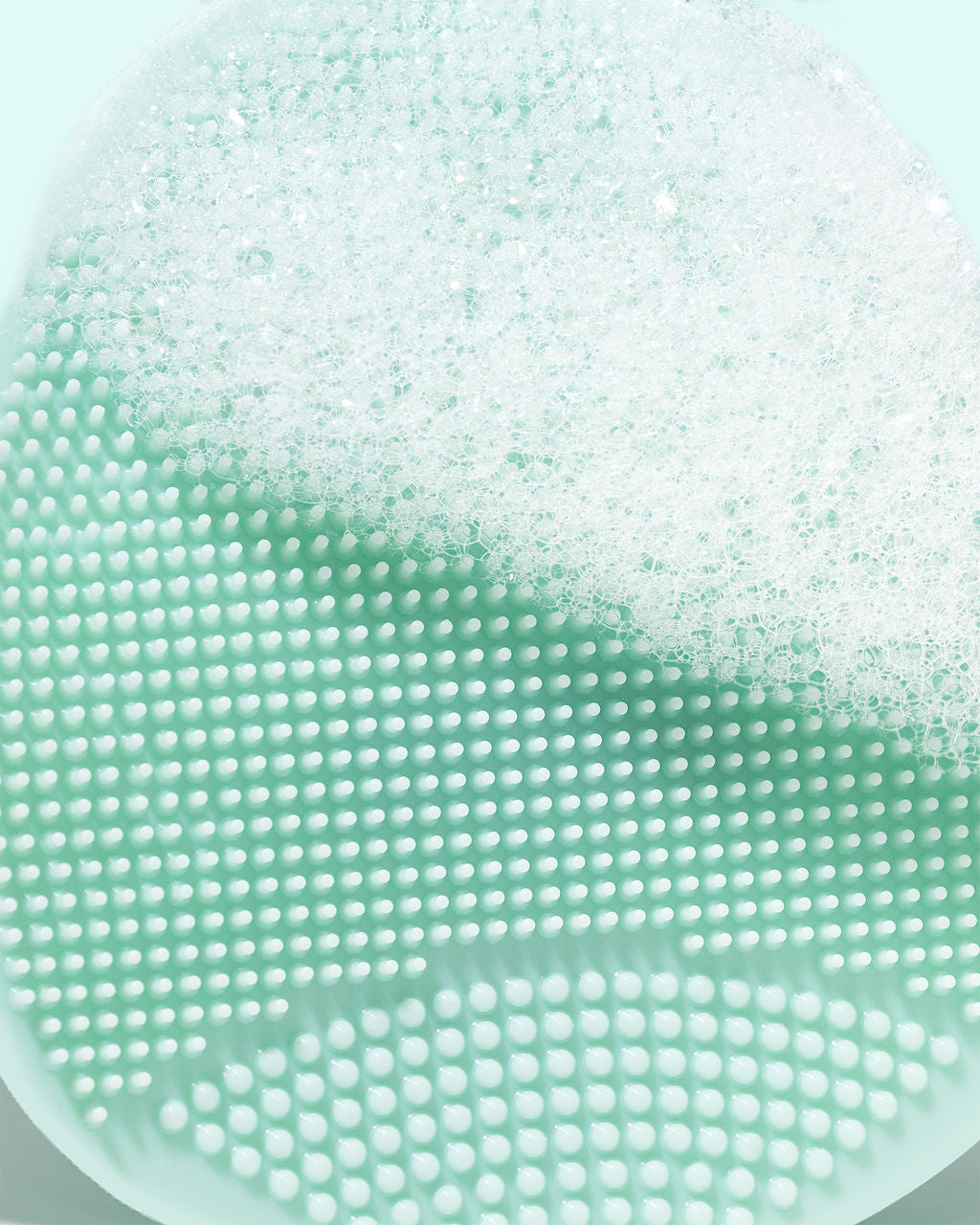 Close-up of TRUYU mint silicone facial exfoliator with textured surface and bubbles